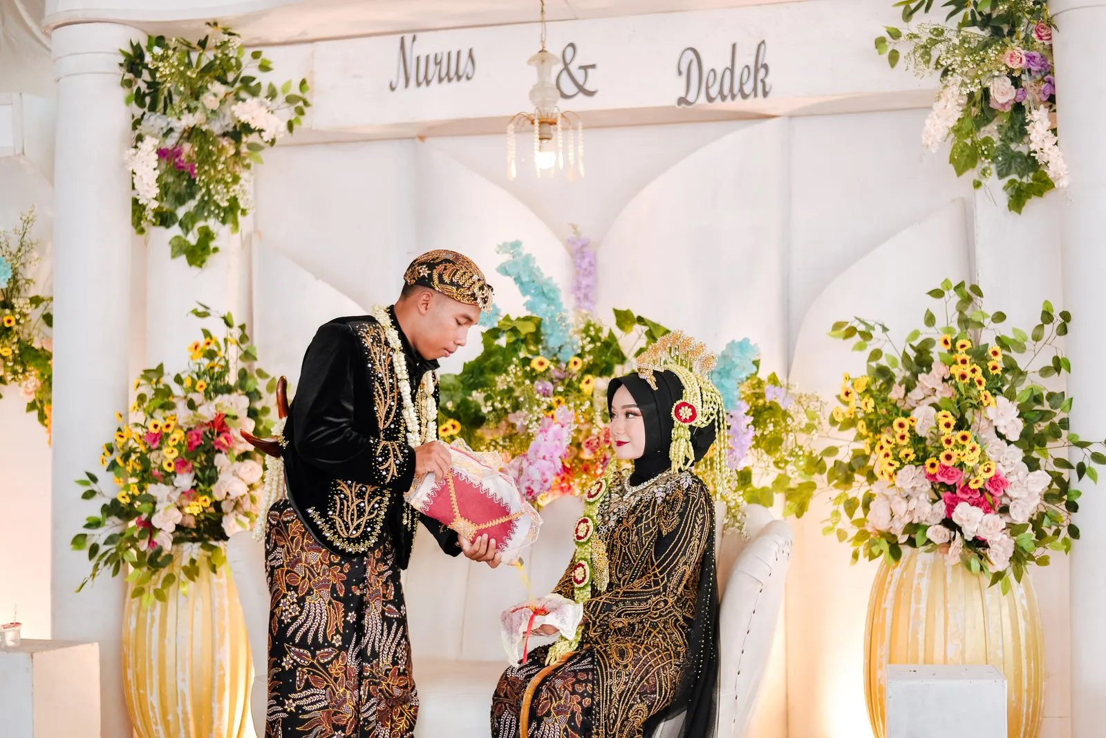 Elegant Javanese wedding ceremony featuring vibrant floral decor and traditional attire.